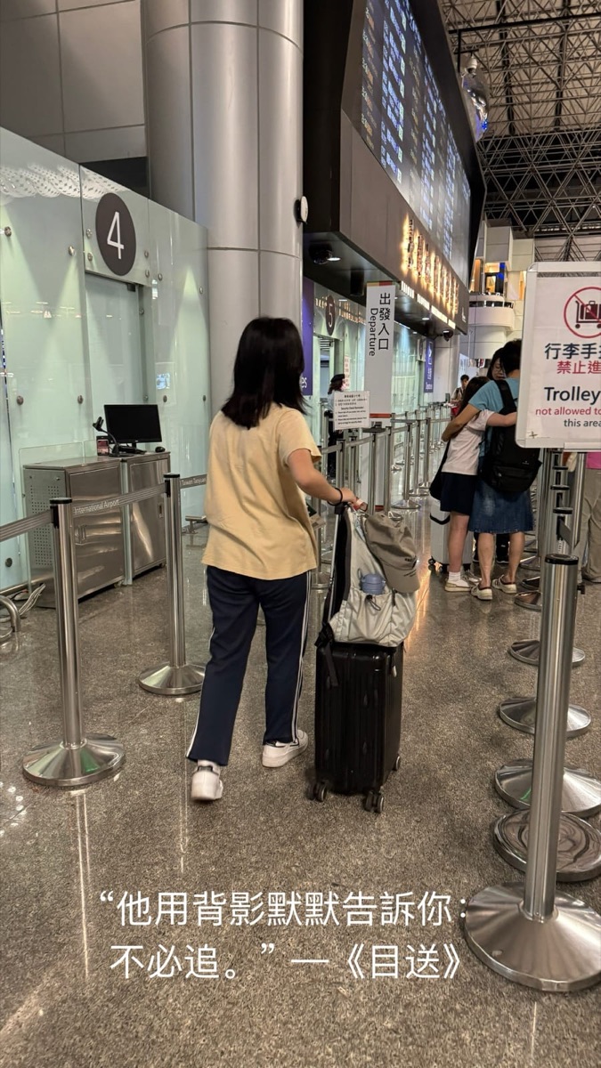 一名少女拉著行李箱走向機場出境通道